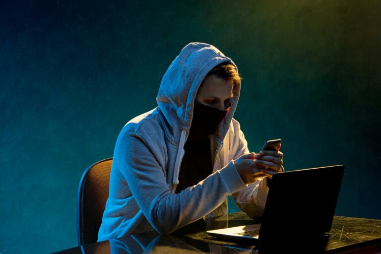 hooded computer hacker stealing information with laptop 1024x683 1