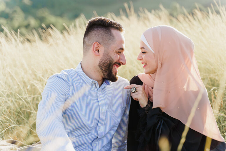 muslim love story mixed couple seats grass smiles hugs