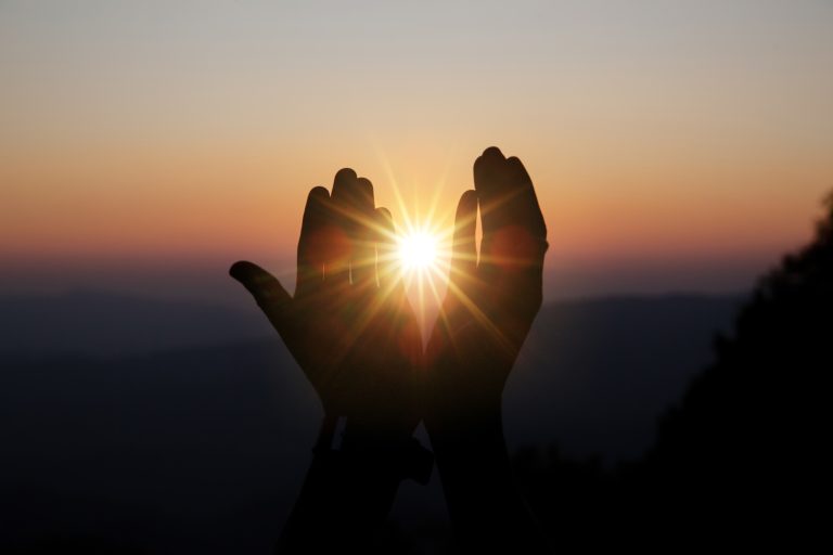 spiritual prayer hands sun shine with blurred beautiful sunset